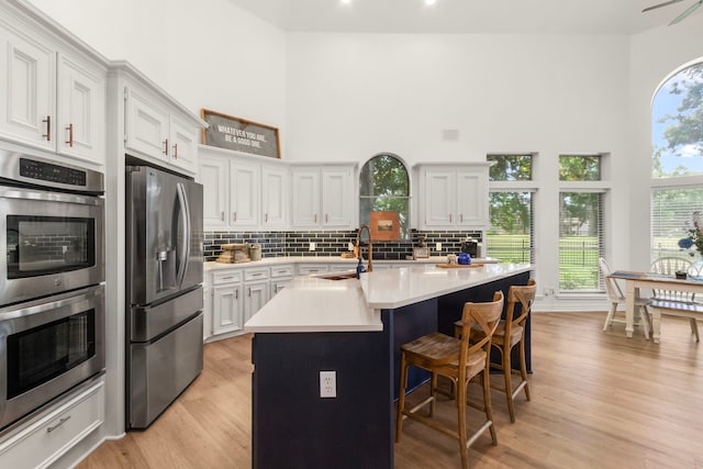 2623 Old S Dr, Richmond, TX 77406 - kitchen with appliances with stainless steel finishes, a sink, decorative backsplash, light countertops, and a towering ceiling