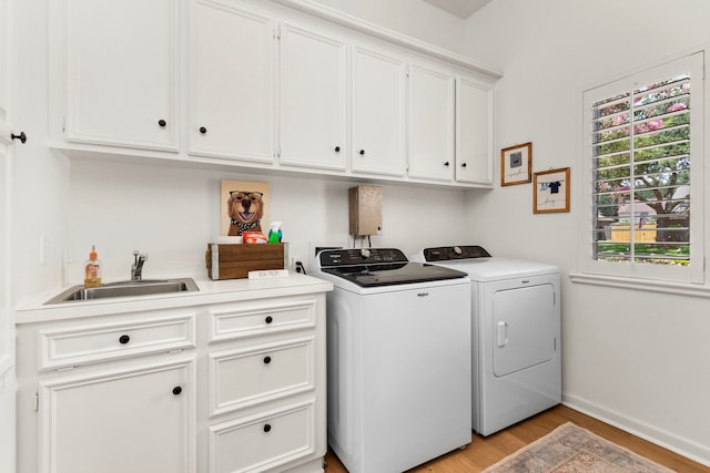 2623 Old S Dr, Richmond, TX 77406 - laundry area featuring washer and dryer, cabinet space, light wood finished floors, and baseboards