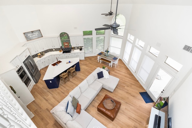 2623 Old S Dr, Richmond, TX 77406 - living area featuring a towering ceiling, ceiling fan, and light wood-style floors
