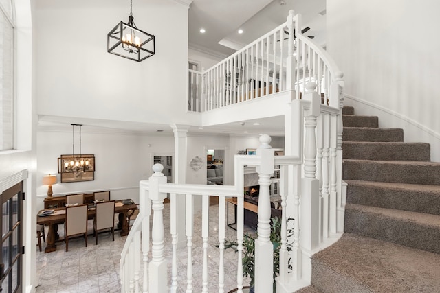 2623 Old S Dr, Richmond, TX 77406 - stairway featuring a warm lit fireplace, a chandelier, a towering ceiling, ornamental molding, and recessed lighting