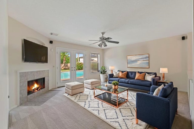 19126 Edens Dawn Dr, Tomball, TX 77375 - living room featuring light carpet, a tile fireplace, french doors, and ceiling fan