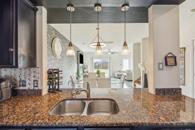 15203 Albert Oak Dr, Humble, TX 77396 - kitchen featuring a sink, dark stone countertops, open floor plan, and decorative light fixtures
