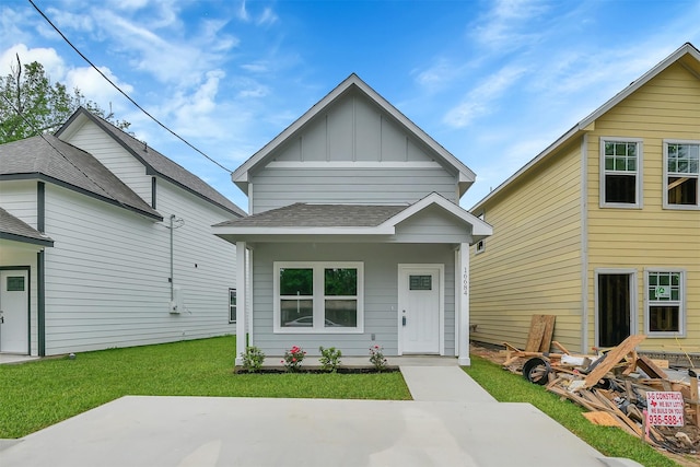16684 E Ivanhoe, Montgomery, TX 77316 - shotgun-style home featuring board and batten siding, a patio area, a front yard, and roof with shingles