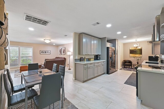 2402 Pine St, Galveston, TX 77551 - kitchen with gray cabinetry, stainless steel fridge with ice dispenser, a sink, light countertops, and recessed lighting