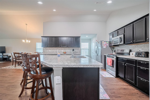 21018 Whitehaven Bluff Trl, Katy, TX 77449 - kitchen with appliances with stainless steel finishes, a sink, light countertops, vaulted ceiling, and backsplash