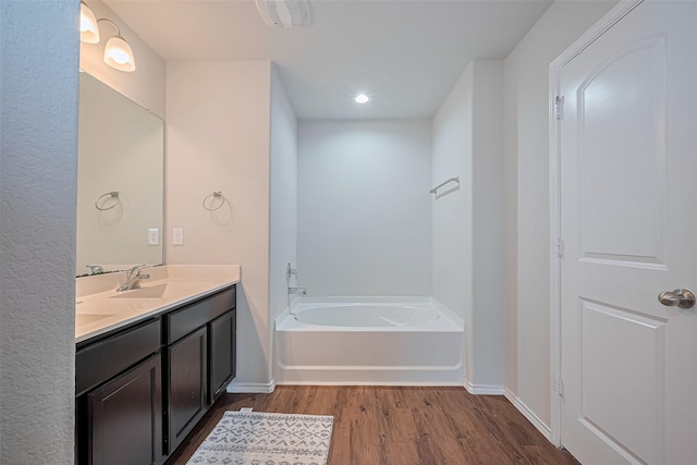 21018 Whitehaven Bluff Trl, Katy, TX 77449 - full bathroom featuring wood finished floors, a garden tub, double vanity, baseboards, and recessed lighting