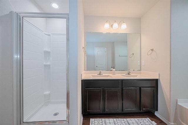 21018 Whitehaven Bluff Trl, Katy, TX 77449 - bathroom featuring double vanity, a stall shower, wood finished floors, and baseboards