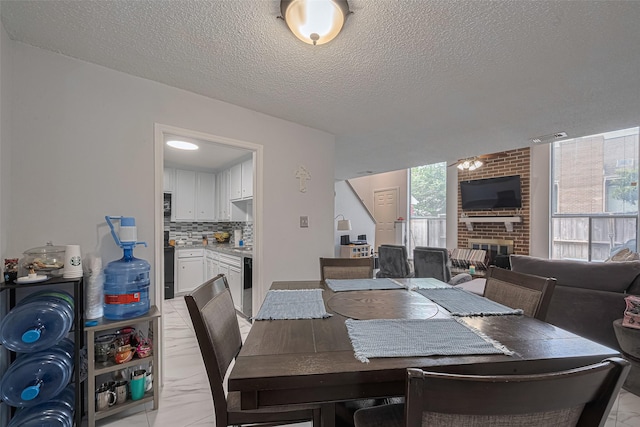 13798 Hollowgreen Dr Unit 305, Houston, TX 77082 - dining room with a textured ceiling and a brick fireplace