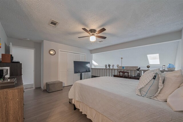 13798 Hollowgreen Dr Unit 305, Houston, TX 77082 - bedroom featuring wood finished floors, a closet, a skylight, ceiling fan, and a textured ceiling