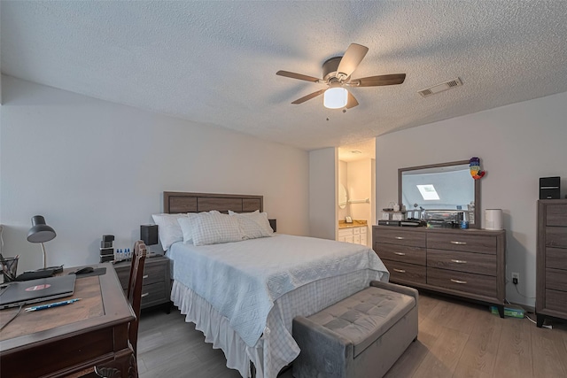 13798 Hollowgreen Dr Unit 305, Houston, TX 77082 - bedroom featuring wood finished floors, a textured ceiling, a desk, a ceiling fan, and connected bathroom