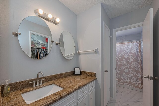 13798 Hollowgreen Dr Unit 305, Houston, TX 77082 - bathroom with vanity, marble finish flooring, a textured ceiling, and a shower with curtain