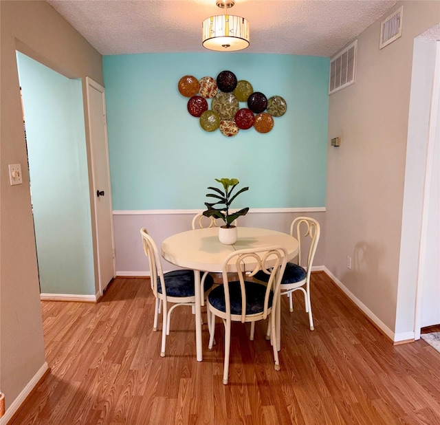 2120 El Paseo St Unit 310, Houston, TX 77054 - dining space featuring wood finished floors, a textured ceiling, and baseboards