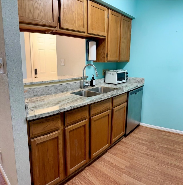 2120 El Paseo St Unit 310, Houston, TX 77054 - kitchen featuring a sink, stainless steel dishwasher, white microwave, brown cabinets, and light wood finished floors