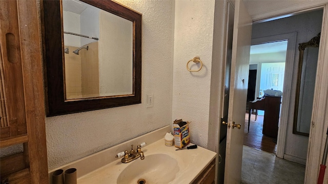 7622 Delavan Dr, Houston, TX 77028 - bathroom with a textured wall, vanity, and a shower