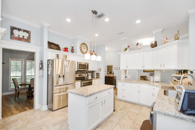 120 Brazos River Rd Unit 400, Freeport, TX 77541 - kitchen with appliances with stainless steel finishes, white cabinetry, crown molding, a kitchen island, and light stone counters