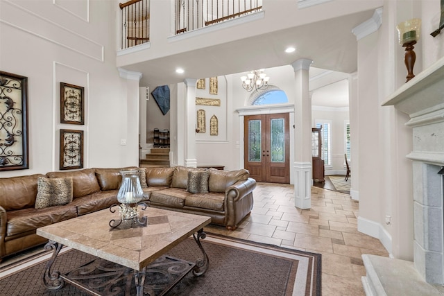 9030 Royal Crest Ln, Richmond, TX 77469 - living room featuring stone tile floors, stairs, a high ceiling, a chandelier, and ornamental molding