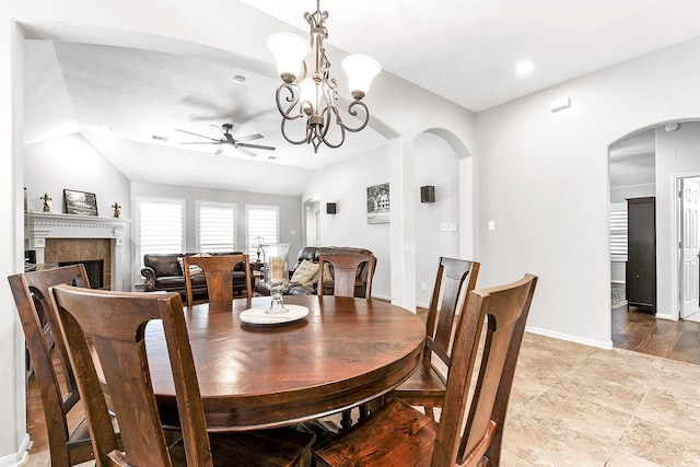 2911 Fair Chase Dr, Katy, TX 77494 - dining space featuring ceiling fan, arched walkways, a fireplace, a chandelier, and lofted ceiling