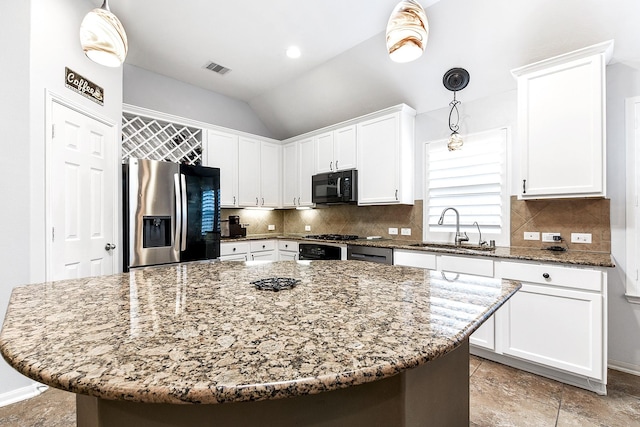 2911 Fair Chase Dr, Katy, TX 77494 - kitchen with stainless steel fridge, black microwave, a sink, white cabinets, and light stone counters