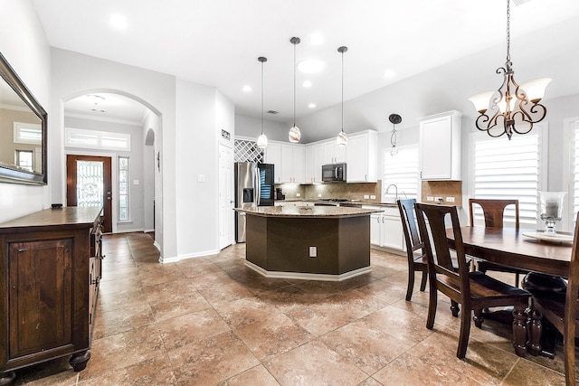 2911 Fair Chase Dr, Katy, TX 77494 - kitchen featuring stainless steel appliances, a sink, healthy amount of natural light, arched walkways, and ornamental molding