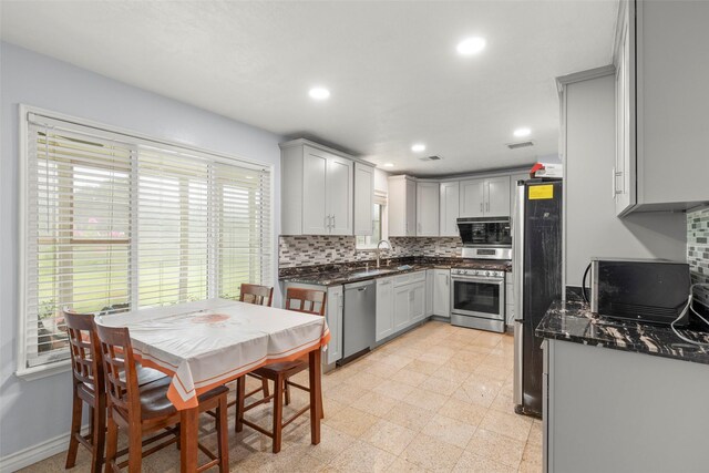 15119 Plaza Libre Dr, Houston, TX 77083 - kitchen featuring appliances with stainless steel finishes, a sink, decorative backsplash, recessed lighting, and dark stone counters