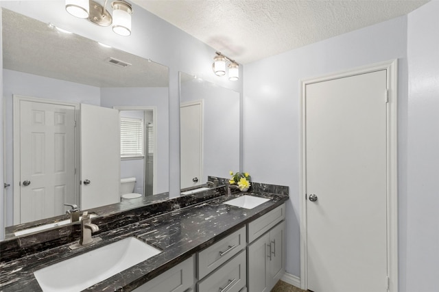15119 Plaza Libre Dr, Houston, TX 77083 - full bath featuring toilet, double vanity, and a textured ceiling