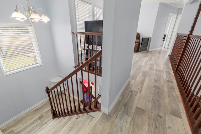 15119 Plaza Libre Dr, Houston, TX 77083 - hall with wood finished floors, a chandelier, an upstairs landing, and baseboards