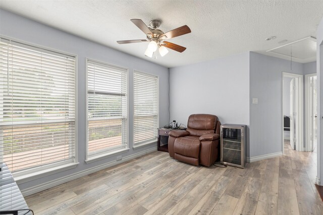 15119 Plaza Libre Dr, Houston, TX 77083 - sitting room featuring attic access, beverage cooler, a ceiling fan, baseboards, and light wood-type flooring