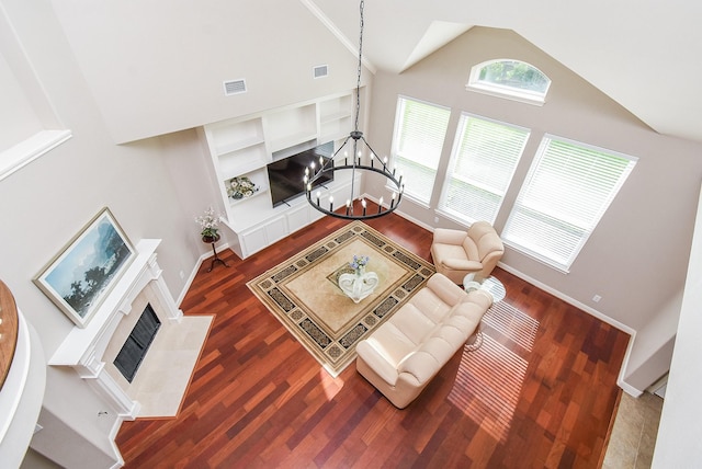 7111 Morrow Ct, Sugar Land, TX 77479 - living room featuring a chandelier, dark wood finished floors, a fireplace, built in shelves, and high vaulted ceiling