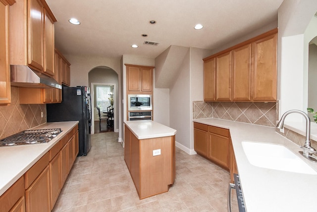 7111 Morrow Ct, Sugar Land, TX 77479 - kitchen with appliances with stainless steel finishes, arched walkways, under cabinet range hood, recessed lighting, and backsplash