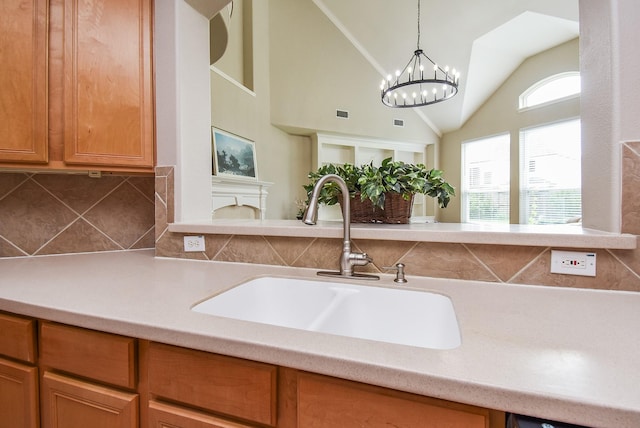 7111 Morrow Ct, Sugar Land, TX 77479 - kitchen with tasteful backsplash, light countertops, vaulted ceiling, pendant lighting, and brown cabinets
