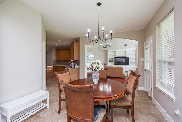 7111 Morrow Ct, Sugar Land, TX 77479 - dining space with a chandelier, light tile patterned flooring, and arched walkways