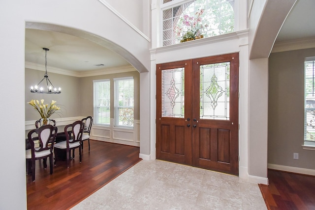 7111 Morrow Ct, Sugar Land, TX 77479 - entrance foyer featuring arched walkways, a chandelier, crown molding, and wood finished floors