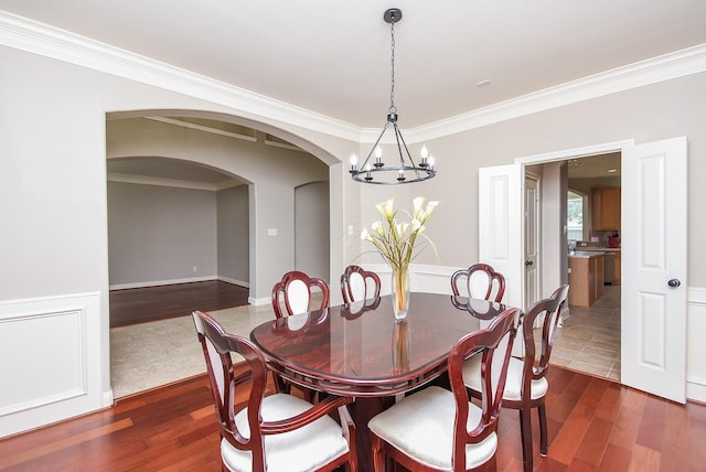 7111 Morrow Ct, Sugar Land, TX 77479 - dining area featuring arched walkways, a chandelier, dark wood-type flooring, and ornamental molding