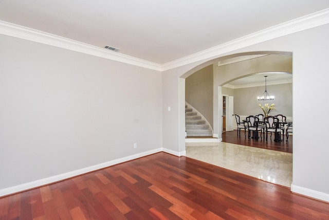 7111 Morrow Ct, Sugar Land, TX 77479 - spare room featuring wood finished floors, ornamental molding, arched walkways, stairs, and a chandelier