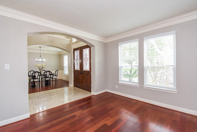 7111 Morrow Ct, Sugar Land, TX 77479 - entrance foyer featuring dark wood-style flooring, ornamental molding, arched walkways, and a chandelier