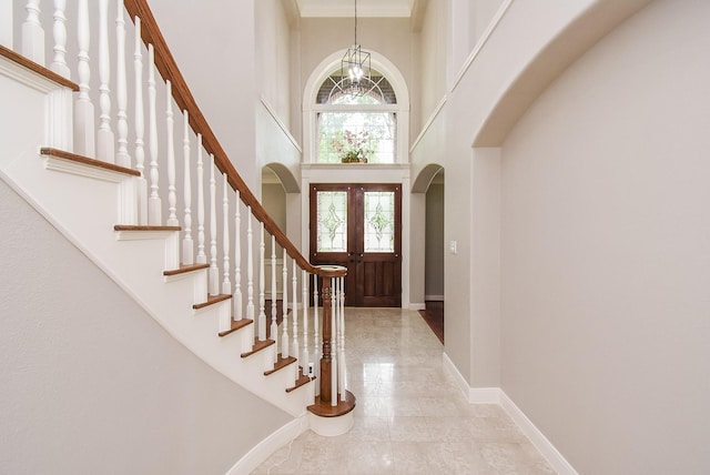 7111 Morrow Ct, Sugar Land, TX 77479 - foyer featuring arched walkways, a high ceiling, a chandelier, stairs, and ornamental molding
