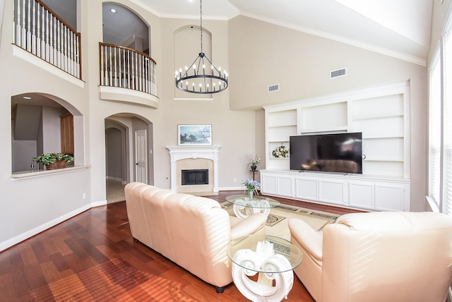 7111 Morrow Ct, Sugar Land, TX 77479 - living room featuring dark wood finished floors, plenty of natural light, a chandelier, high vaulted ceiling, and a glass covered fireplace