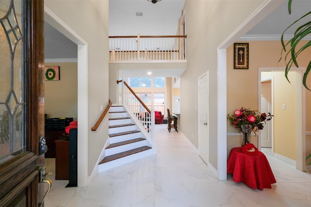 12427 Shadycrest Dr, Houston, TX 77082 - foyer entrance with marble look tile flooring, stairs, a high ceiling, crown molding, and baseboards