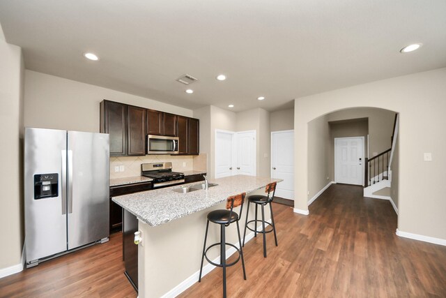 24739 Lorenzo Glaze Trl, Katy, TX 77493 - kitchen with stainless steel appliances, arched walkways, baseboards, a sink, and recessed lighting