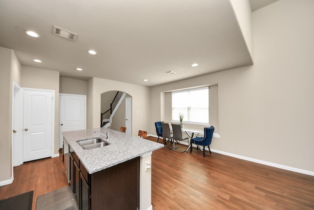 24739 Lorenzo Glaze Trl, Katy, TX 77493 - kitchen featuring a sink, arched walkways, wood finished floors, baseboards, and recessed lighting