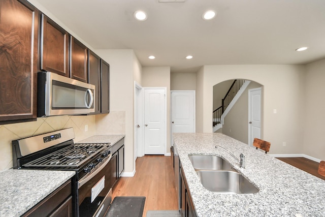 24739 Lorenzo Glaze Trl, Katy, TX 77493 - kitchen featuring appliances with stainless steel finishes, light wood-style floors, a sink, baseboards, and recessed lighting
