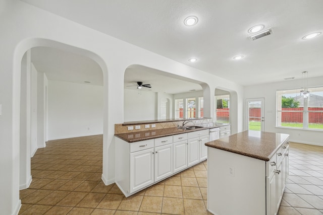 26402 Larkspur Ridge Dr, Katy, TX 77494 - kitchen with arched walkways, a center island, ceiling fan, white cabinetry, and recessed lighting