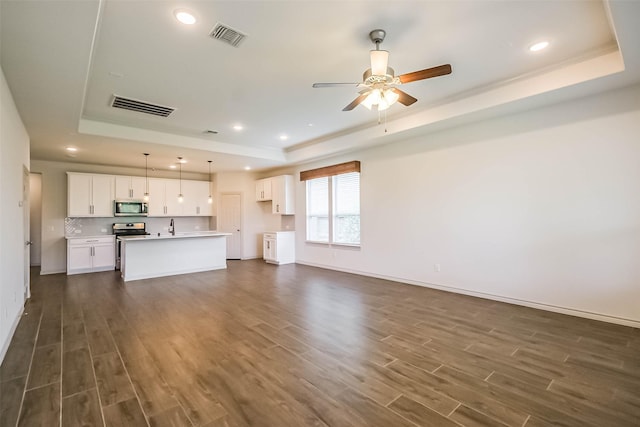 11514 Harmony Summit Trce, Richmond, TX 77406 - unfurnished living room with a tray ceiling, dark wood finished floors, ceiling fan, and recessed lighting