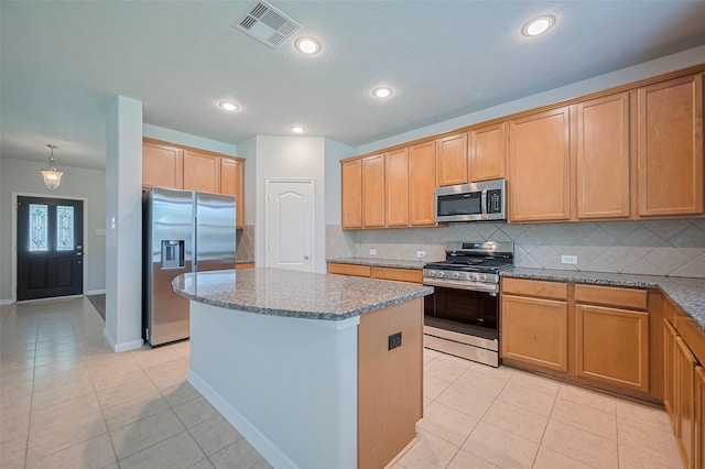24523 Carlton Springs Ln, Katy, TX 77494 - kitchen with stainless steel appliances, a kitchen island, light tile patterned floors, decorative backsplash, and recessed lighting
