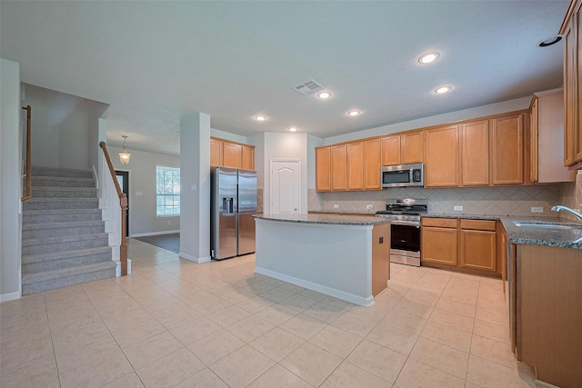 24523 Carlton Springs Ln, Katy, TX 77494 - kitchen with appliances with stainless steel finishes, a sink, light tile patterned flooring, dark stone countertops, and recessed lighting