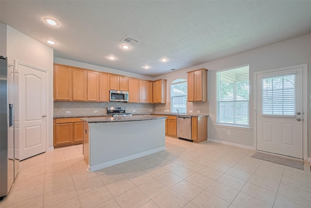 24523 Carlton Springs Ln, Katy, TX 77494 - kitchen featuring stainless steel appliances, light tile patterned floors, backsplash, a kitchen island, and recessed lighting