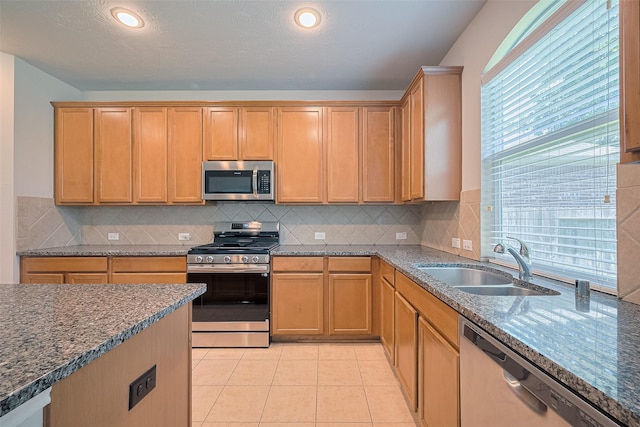 24523 Carlton Springs Ln, Katy, TX 77494 - kitchen featuring stainless steel appliances, a sink, dark stone countertops, decorative backsplash, and recessed lighting