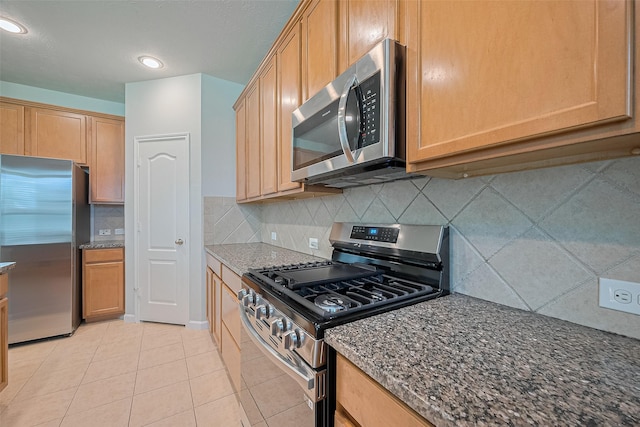 24523 Carlton Springs Ln, Katy, TX 77494 - kitchen featuring stainless steel appliances, dark stone counters, light tile patterned floors, backsplash, and recessed lighting