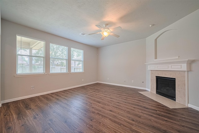 24523 Carlton Springs Ln, Katy, TX 77494 - unfurnished living room featuring ceiling fan, dark wood finished floors, a textured ceiling, a fireplace, and baseboards