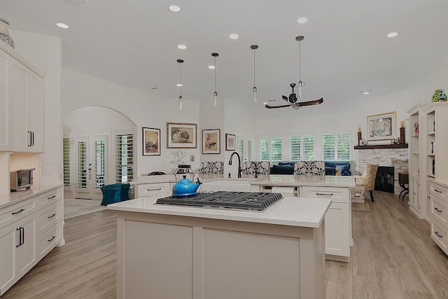 15569 Zoe Loop Dr, Montgomery, TX 77316 - kitchen featuring a sink, a large island, stainless steel gas stovetop, a ceiling fan, and open floor plan